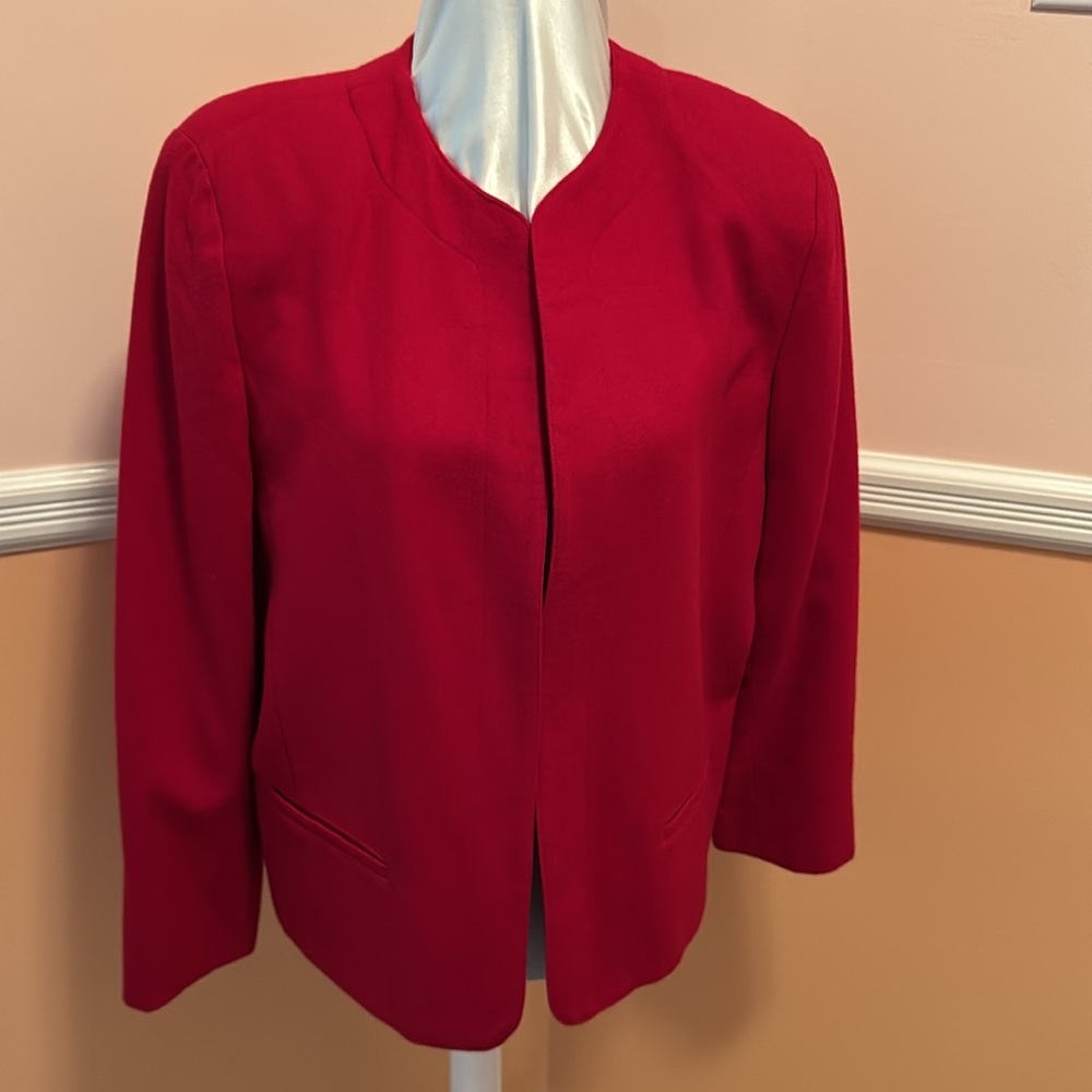 Red wool lined jacket. Small pockets lower front sides. Buttons on sleeves.